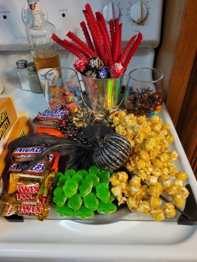Char-Boo-Terie Board A charcuterie board made out of Halloween candy and caramel corn decorated with a spray of black flowers